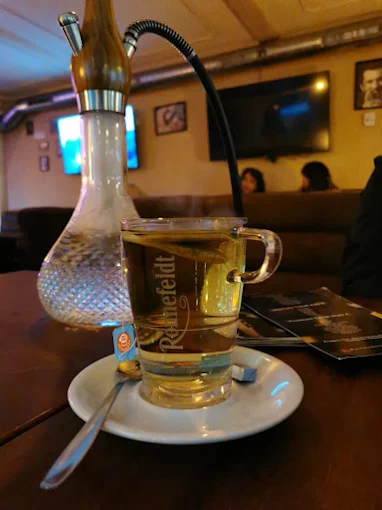 Shisha und ein Glas Tee an einem Tisch im Pik Ass – Moon